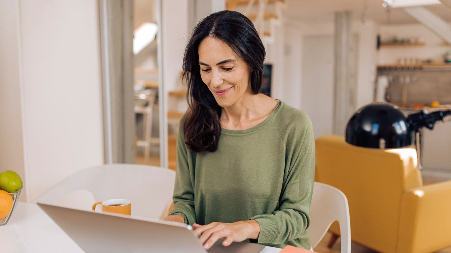 Frau sitzt am Laptop.